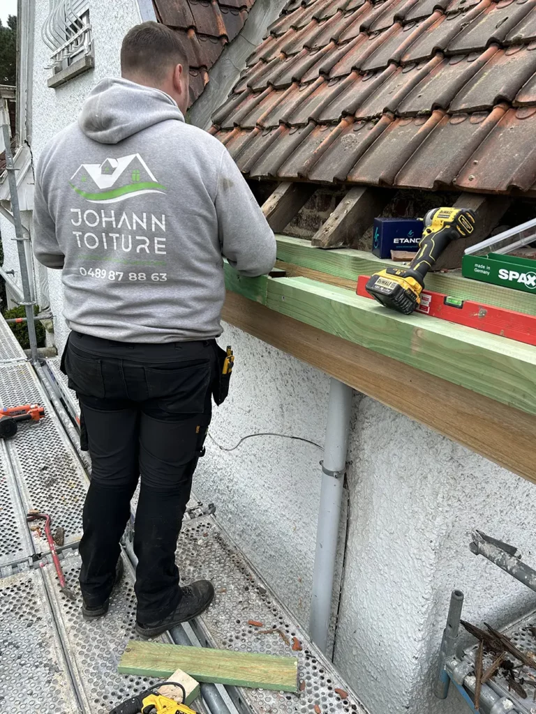 couvreur qui remplace une corniche
